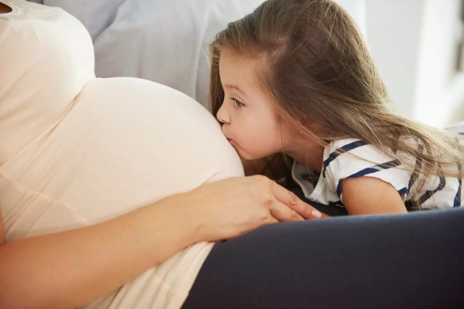 little-girl-kissing-her-future-sibling